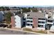 Exterior view of a multi-story home featuring brick accents, balconies, and a well-maintained landscape at 14495 E 1St Dr # C1, Aurora, CO 80011