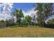 An open backyard view with mature trees, perfect for recreation and relaxation at 5942 Poplar St, Commerce City, CO 80022