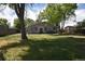 A beautiful backyard with lush green grass, mature trees, and a cozy home exterior at 5942 Poplar St, Commerce City, CO 80022