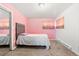 Bedroom featuring a pink accent wall, a bed and closet with mirrored doors at 5942 Poplar St, Commerce City, CO 80022