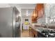 A kitchen with stainless steel appliances, wooden cabinets, and access to laundry at 5942 Poplar St, Commerce City, CO 80022