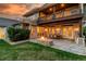 Backyard at twilight showcasing the patio fireplace, covered deck, and landscaped yard, creating a serene outdoor space at 295 Jersey St, Denver, CO 80220