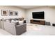 Cozy basement living area with a gray sectional sofa, entertainment center, and decorative accents at 295 Jersey St, Denver, CO 80220