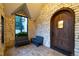 Arched wood front door with stone surround and adjacent seating area at 295 Jersey St, Denver, CO 80220