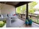 Inviting covered porch with cozy seating, beautiful flower pots, and a view of lush greenery at 295 Jersey St, Denver, CO 80220
