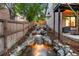 Serene backyard waterfall feature surrounded by lush landscaping and a privacy fence at 9161 W Lake Dr, Littleton, CO 80123