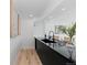 Basement area features a bar with black countertop and seating, with light wood floors and white walls at 9161 W Lake Dr, Littleton, CO 80123