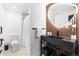 Modern bathroom featuring stylish vanity, sleek fixtures, decorative wood wall, and oval mirror with soft lighting at 9161 W Lake Dr, Littleton, CO 80123