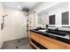 Sleek bathroom featuring a double vanity with modern fixtures and a glass-enclosed shower with rainfall shower head at 9161 W Lake Dr, Littleton, CO 80123