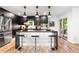 Modern kitchen features stainless steel appliances, a central island with bar seating, and stylish pendant lighting at 9161 W Lake Dr, Littleton, CO 80123