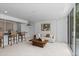 Open-concept living room with bar, stylish furniture, contemporary art, and a bright, inviting atmosphere with backyard views at 9161 W Lake Dr, Littleton, CO 80123