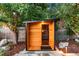 Backyard sauna featuring a modern design with glass door, nestled among mature trees at 9161 W Lake Dr, Littleton, CO 80123