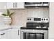 Kitchen features a stainless steel oven and white cabinets with black hardware at 4625 Webster St, Wheat Ridge, CO 80033