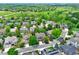 Aerial view of a home in a lush neighborhood with green spaces, mature trees, and a clear blue sky at 8927 Green Meadows Ln, Highlands Ranch, CO 80126