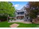 Expansive backyard featuring a stone patio, lush lawn, mature trees, outdoor seating, and a second story deck at 8927 Green Meadows Ln, Highlands Ranch, CO 80126