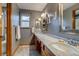 Elegant bathroom featuring a marble countertop, double sinks, and natural light from the window at 8927 Green Meadows Ln, Highlands Ranch, CO 80126