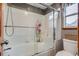 A clean bathroom features glass enclosed shower and tub combo with storage at 8927 Green Meadows Ln, Highlands Ranch, CO 80126