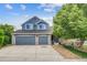 Charming two-story home features a two car garage, a well-manicured front yard, and blue siding at 8927 Green Meadows Ln, Highlands Ranch, CO 80126