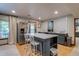 A gray kitchen island offers seating and storage complementing stainless steel appliances and modern finishes at 8927 Green Meadows Ln, Highlands Ranch, CO 80126