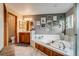 Bright main bathroom with soaking tub, oak cabinets, and an artfully decorated wall at 8927 Green Meadows Ln, Highlands Ranch, CO 80126