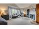 Open main bedroom with a sitting area, fireplace, and a large picture window for ample natural light at 8927 Green Meadows Ln, Highlands Ranch, CO 80126