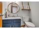 Stylish half bathroom with navy vanity, round mirror, and modern fixtures at 8927 Green Meadows Ln, Highlands Ranch, CO 80126