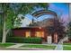Charming brick home featuring a well-manicured lawn, privacy hedge, and a unique rooftop terrace at 865 Delaware St, Denver, CO 80204