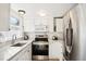 Modern kitchen with white cabinetry, stainless steel appliances, and ample counter space at 5959 S Willow Way, Greenwood Village, CO 80111