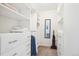 Walk-in closet with closet system, carpet flooring, mirror and visible bedroom behind at 5959 S Willow Way, Greenwood Village, CO 80111