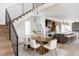 Dining area with modern table and chairs, view into kitchen and stairs with black metal railings at 3437 W 17Th Ave, Denver, CO 80204