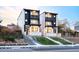 Modern townhomes boast stylish black and white exteriors with balconies, and manicured lawns at 3437 W 17Th Ave, Denver, CO 80204