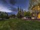 Expansive backyard with lush lawn, mature trees, and a play area, perfect for outdoor activities at 5441 Twilight Way, Parker, CO 80134