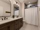 Double vanity bath with dark wood cabinets, a tiled shower, and modern fixtures at 5441 Twilight Way, Parker, CO 80134