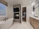 Elegant bathroom featuring a freestanding tub, a modern fireplace, and a door to the primary bedroom at 5441 Twilight Way, Parker, CO 80134