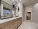 Stylish bathroom with double vanities, modern mirrors, and an adjacent walk-in closet at 5441 Twilight Way, Parker, CO 80134