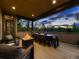 Covered patio featuring a fire pit, dining table, chairs, and sunset views for outdoor enjoyment at 5441 Twilight Way, Parker, CO 80134