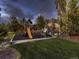 Backyard playground with a slide, swings, and playhouse, set on mulch for safety and fun at 5441 Twilight Way, Parker, CO 80134