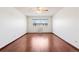 The bare bedroom is spacious with hardwood floors and a large window letting in natural light at 9150 E Center Ave # 9C, Denver, CO 80247