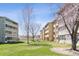 Low angle view of a multi-unit residential building, grass, and trees at 9150 E Center Ave # 9C, Denver, CO 80247