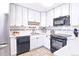 Efficient kitchen featuring white cabinets, black appliances, and tile backsplash at 9150 E Center Ave # 9C, Denver, CO 80247