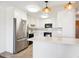 Bright kitchen with white cabinets, stainless steel refrigerator, and peninsula island at 9150 E Center Ave # 9C, Denver, CO 80247