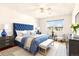 Bedroom with a blue tufted headboard, hardwood floors, and a ceiling fan at 9150 E Center Ave # 9C, Denver, CO 80247