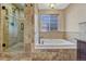 Luxurious primary bathroom with tiled walk-in shower and soaking tub with window at 11730 Crow Hill Dr, Parker, CO 80134