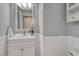 Classic powder room with a white vanity, decorative wainscoting, and a modern faucet at 11730 Crow Hill Dr, Parker, CO 80134
