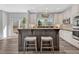 Stylish kitchen island with bar seating, granite countertops, and white cabinetry, offering a perfect spot for casual dining at 11730 Crow Hill Dr, Parker, CO 80134