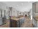 Open-concept kitchen with island cooktop, stainless steel appliances, and seamless transition to the living room with fireplace at 11730 Crow Hill Dr, Parker, CO 80134