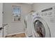 Well-equipped laundry room featuring a front-load washer and dryer with a window at 11730 Crow Hill Dr, Parker, CO 80134