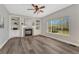 Inviting living room featuring a brick fireplace, custom built-ins, large windows, and wood floors at 11730 Crow Hill Dr, Parker, CO 80134