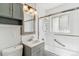 Updated bathroom with a gray vanity, subway tile, and a glass-enclosed shower/tub at 2767 S Linley Ct, Denver, CO 80236