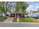 Charming home with red and white siding, a green lawn, and mature shade trees at 2767 S Linley Ct, Denver, CO 80236